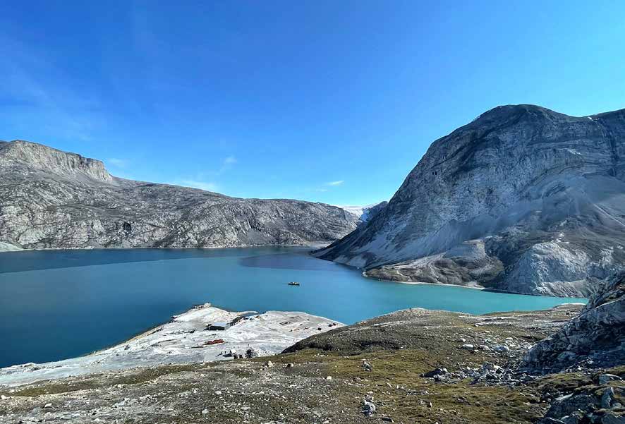 Blick über den Fjord auf die verlassene Minensiedlung Maarmorilik mit hellen Halden