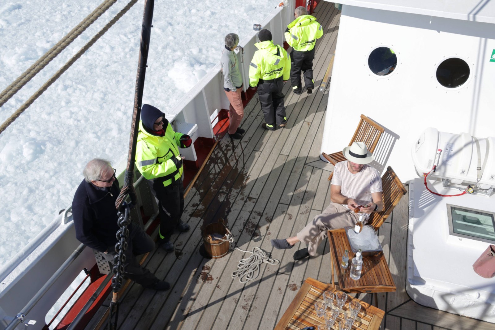 Gäste sitzen bei Sonne und Windstille auf Deckstühlen an Bord der CAPE RACE vor der Gletscherfront