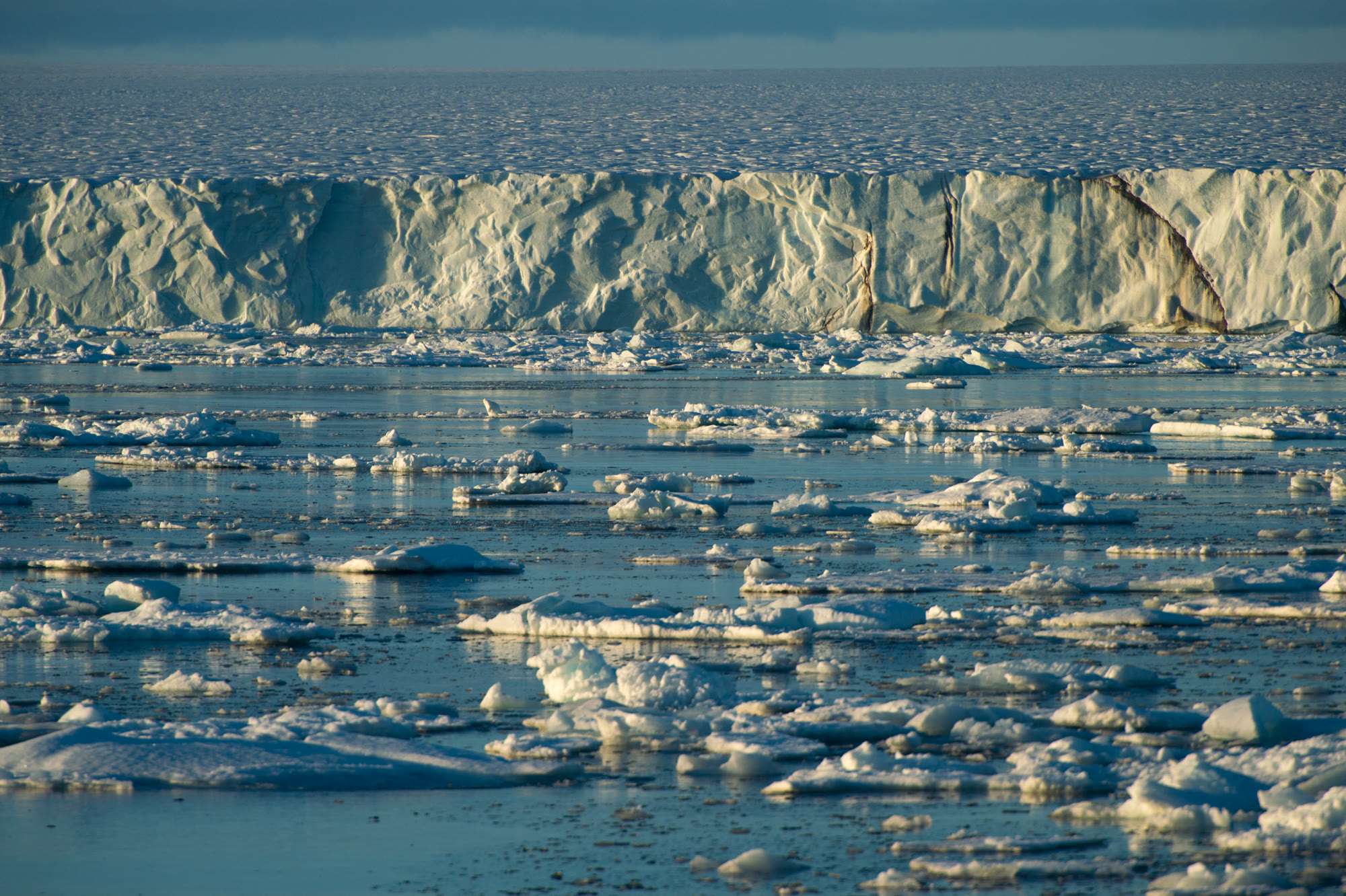 Gletscherfront auf Spitzbergen mit Treibeis im Vordergrund, weiches Licht am späten Abend