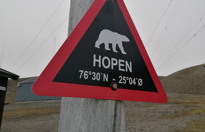 Warnschild mit Eisbärsymbol auf der Insel Hopen mit Positionsangabe 76 Grad 30 Nord und 25 Grad 04 Ost