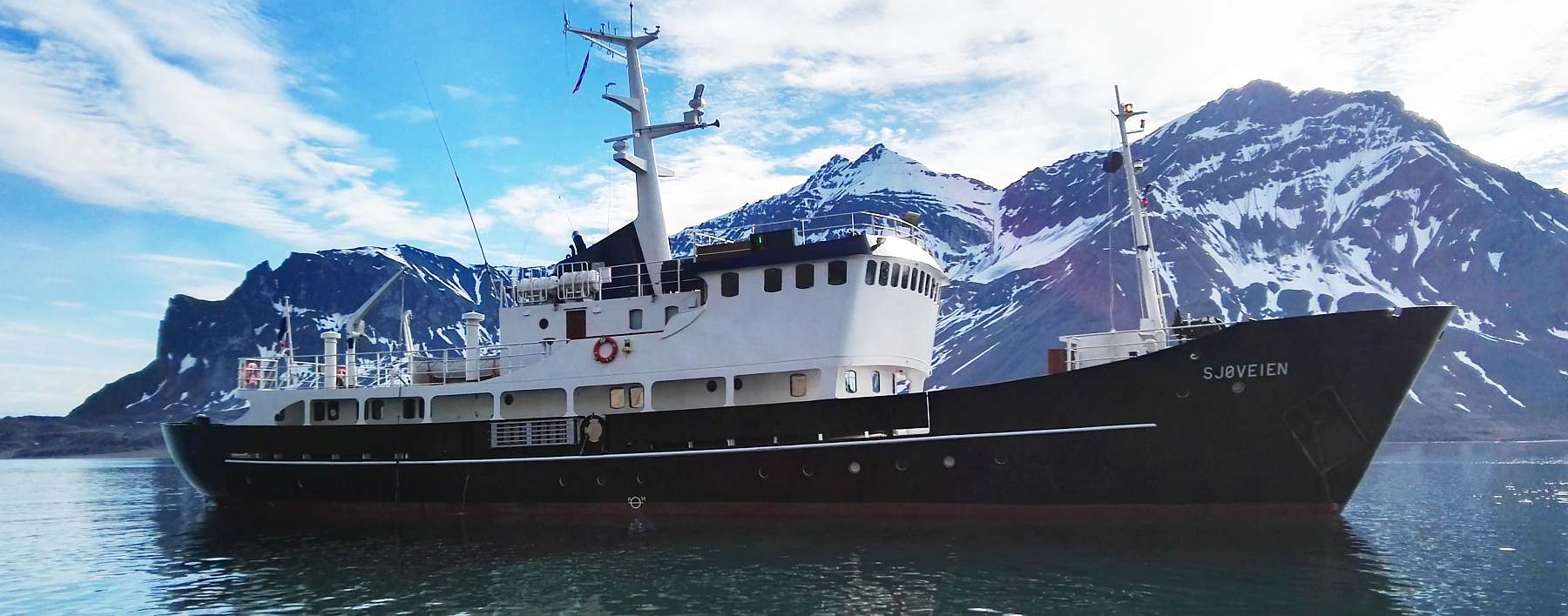 MS Sjøveien vor schneebedeckten Bergen in Spitzbergen